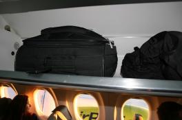 Ручная кладь на багажной полке в салоне самолета
