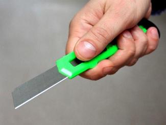 канцелярский нож в руке, фото из открытых истчников