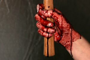 окровавленная палка в руке